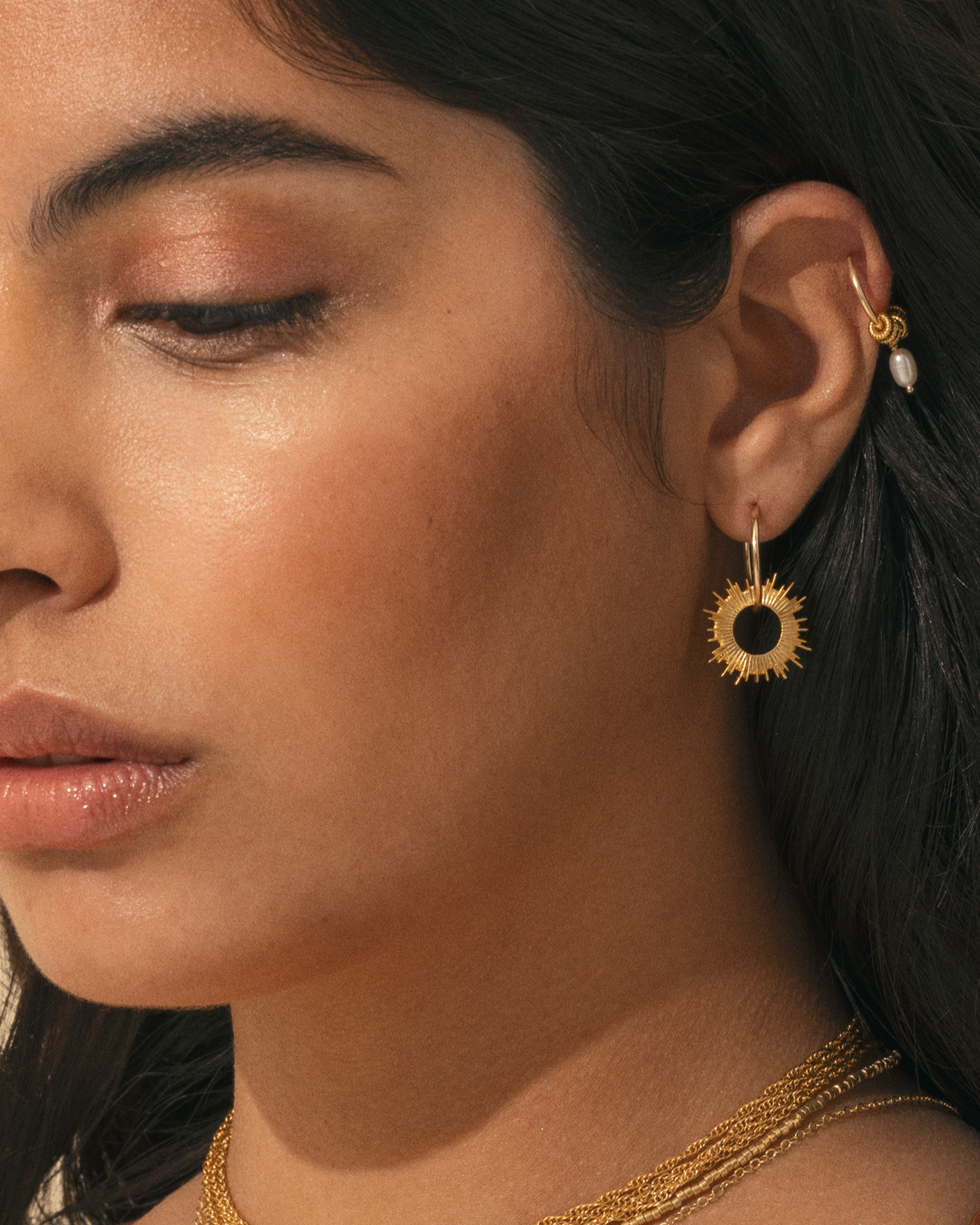 APSARA - Créoles INTI en Gold Filled 14 carats, avec pendentif soleil, portées par une femme. Bijou fait main en France.
