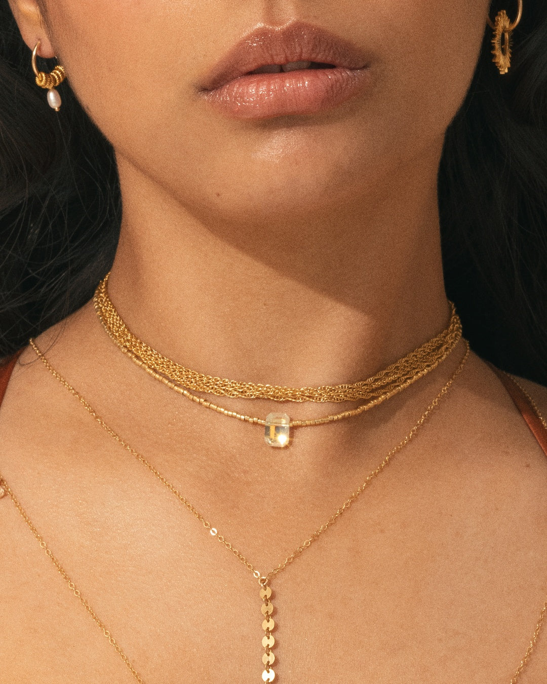 APSARA - Collier ras de cou SHINE BRIGHT porter par une femme : fines perles dorées et pendentif cristal Swarovski brillant comme un diamant. Bijou fait main en France.