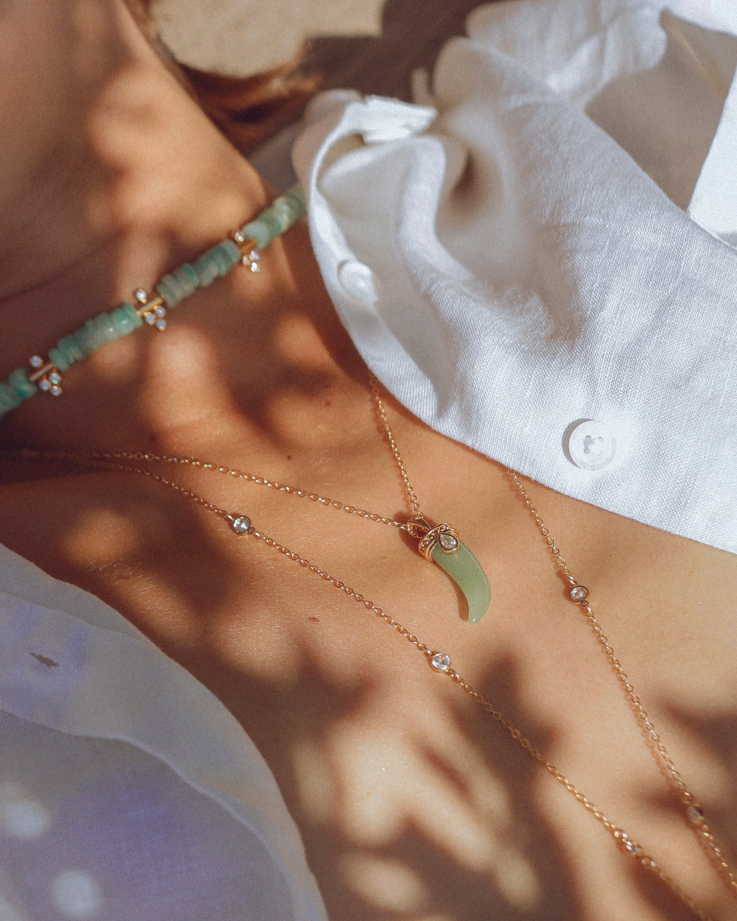 Accumulation de colliers dorés APSARA, dont le collier Moana orné d'amazonite bleue et d'oxydes de zirconium.