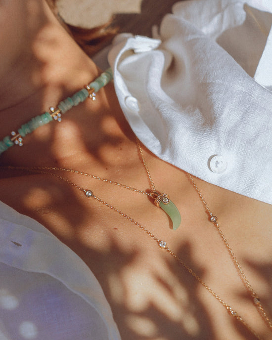 Accumulation de colliers dorés APSARA, dont le collier Moana orné d'amazonite bleue et d'oxydes de zirconium.
