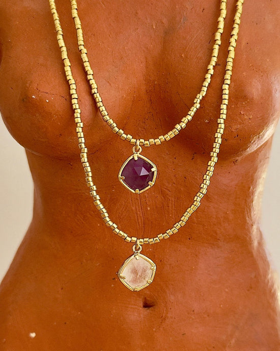 APSARA -  Accumulation de colliers ras-de-cou AMETHYST en améthyste et CRISTAL CLEAR en cristal de roche sur un buste de femme sculpté.