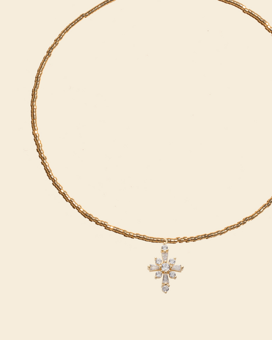 APSARA - Collier ras-de-cou LUCE en perles dorées avec pendentif croix et cristaux zircons.