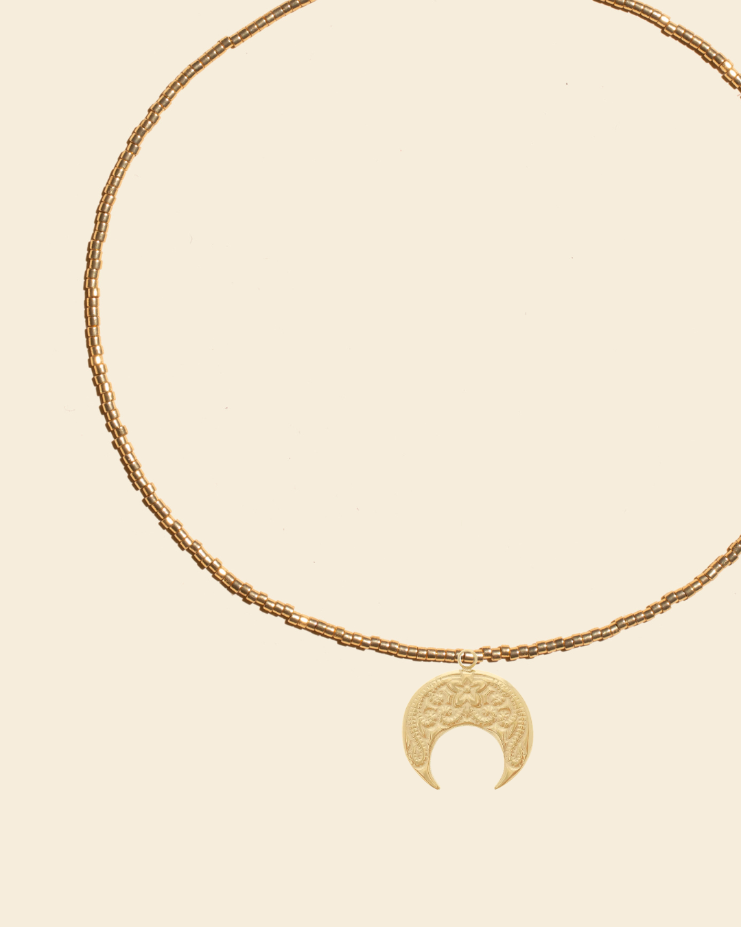 APSARA - Collier ras-de-cou ESMEE en perles dorées avec pendentif croissant de Lune dorée.