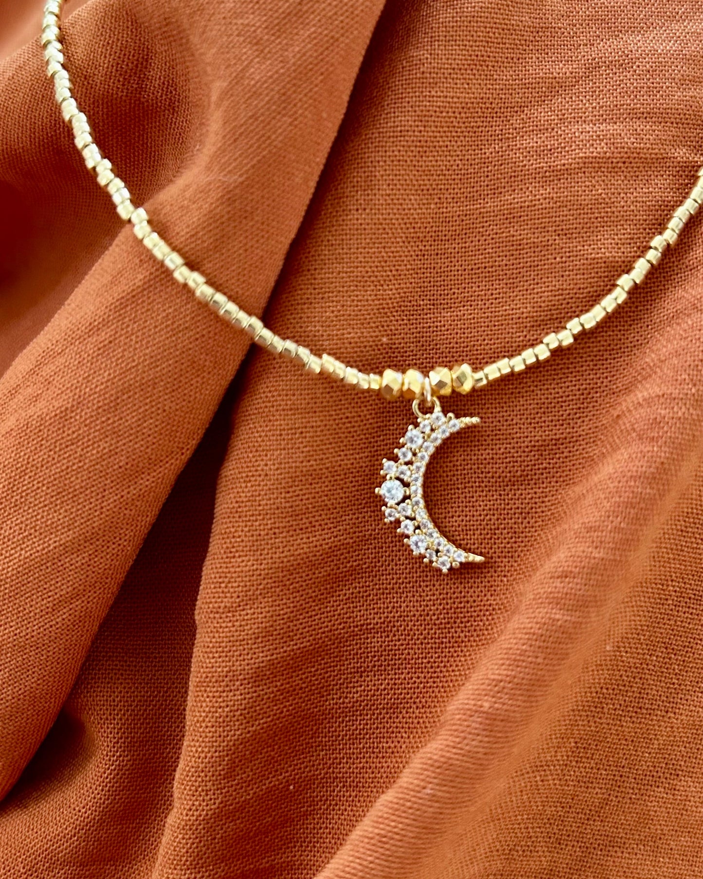 APSARA - Collier ras de cou MOONLIGHT en fines perles dorées et pendentif Lune serti de zircons brillants. Bijou fait main en France.