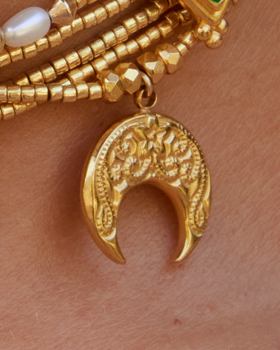 APSARA - Collier ras-de-cou ESMEE en perles dorées avec pendentif croissant de Lune dorée porté en accumulation.