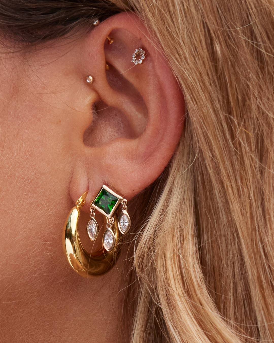 Boucles d'oreilles pendantes HEAVEN avec zircons vert émeraude. Gros plan