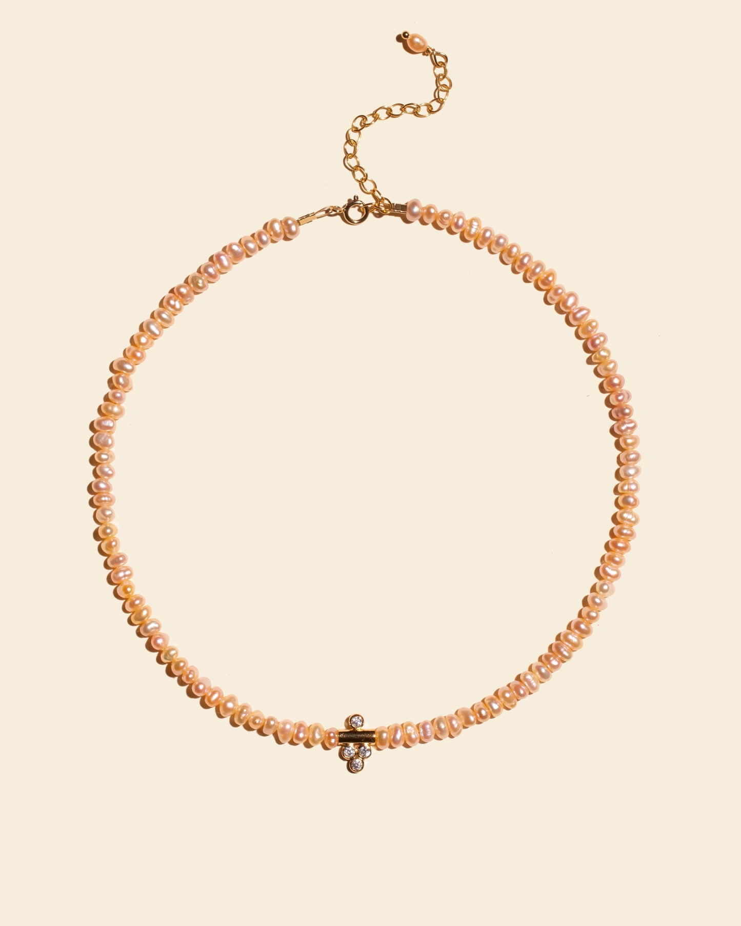 Collier Dalhia APSARA composé de fines perles nacrées roses et d'un délicat pendentif central plaqué or serti de 4 zircons brillants.