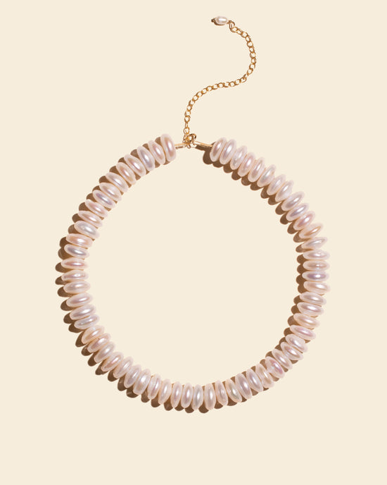 Collier Holika APSARA composé de larges perles rondelles plates en nacre naturelle irisée, avec fermoir doré.