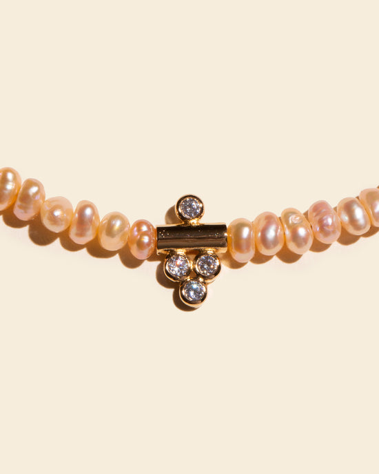 Zoom sur le pendentif plaqué or du collier DALHIA par APSARA, serti de 4 oxydes de zirconium scintillants.