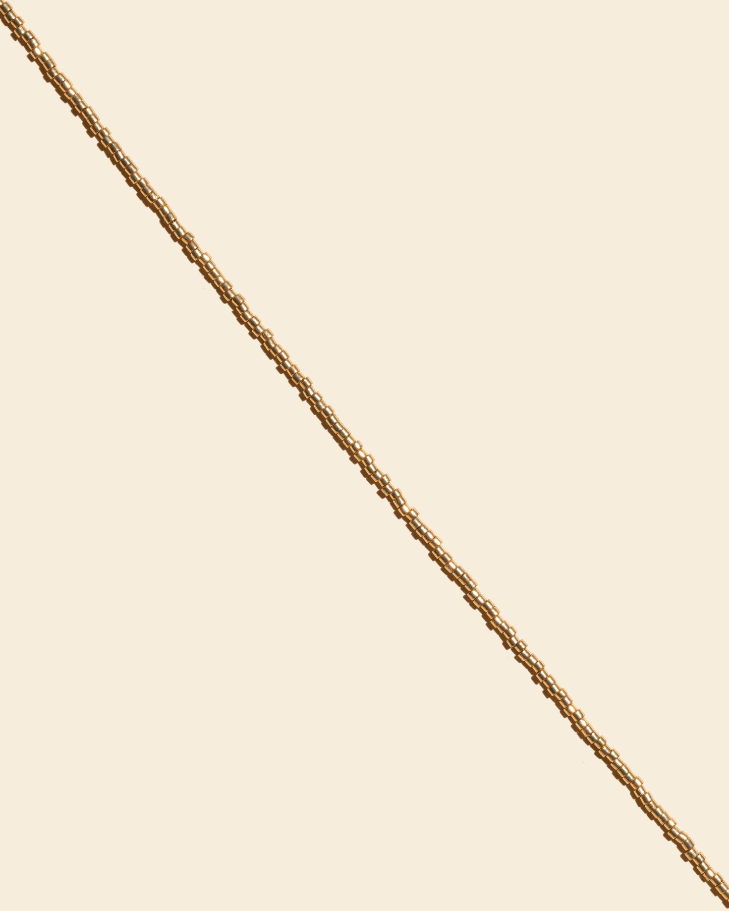 APSARA - Chaîne de taille GOLDY, gros plan. Détail de la fine chaîne dorée et des perles. Bijou fait main.