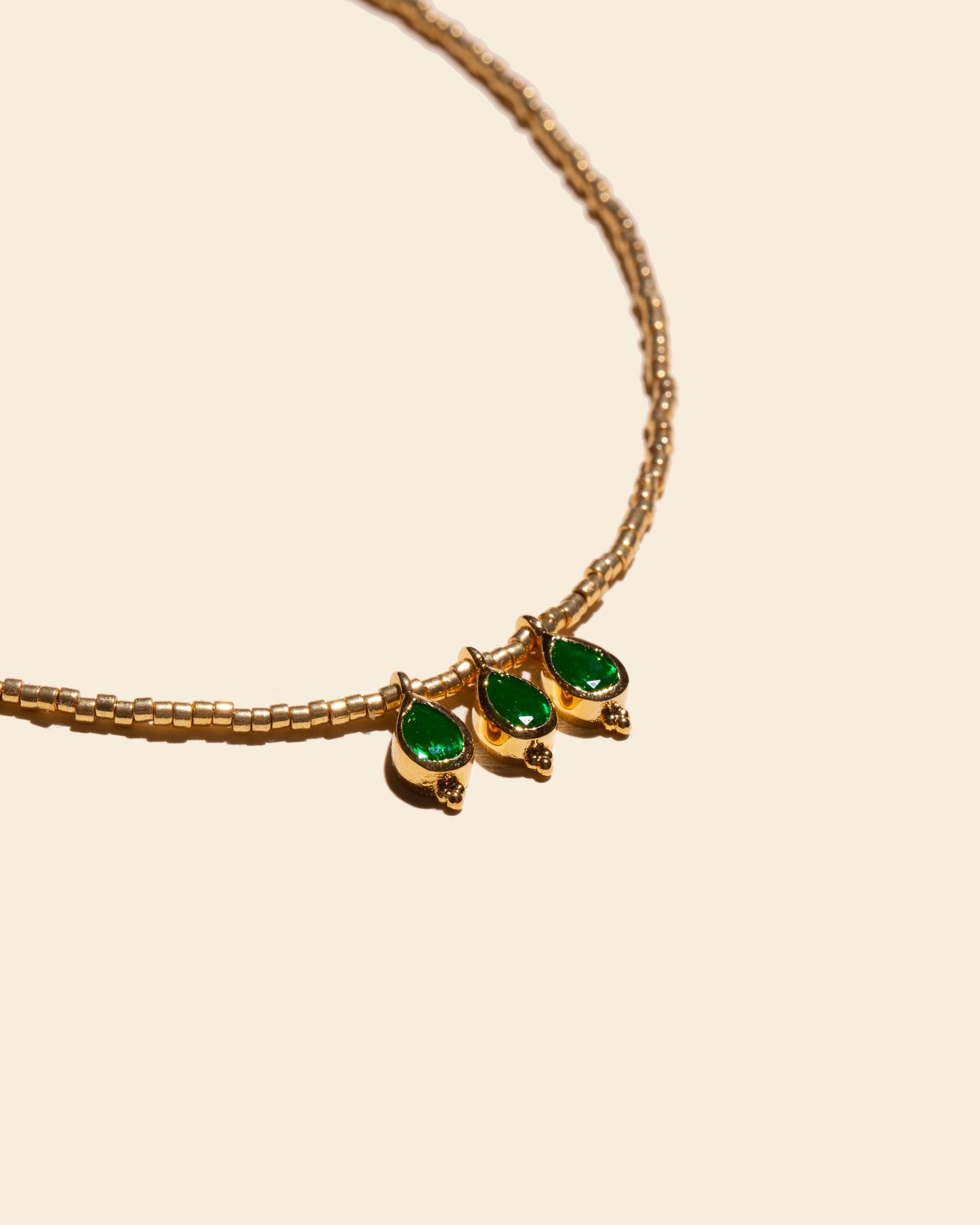 APSARA - Collier ras de cou TALISMAN III en fines perles dorées et pendentif trio de gouttes en tourmaline verte. Bijou fait main en France.