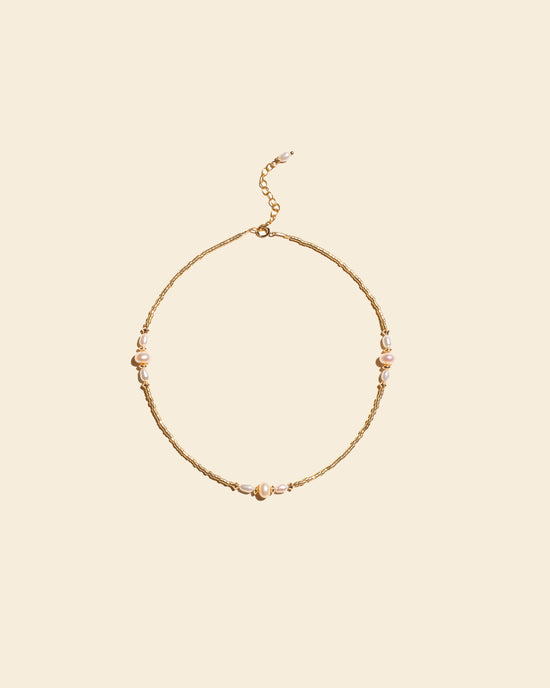 Bracelet de cheville Naïade avec perles nacrées blanches et perles dorées, vu de dessus sur fond blanc. Bijou de créateur Apsara