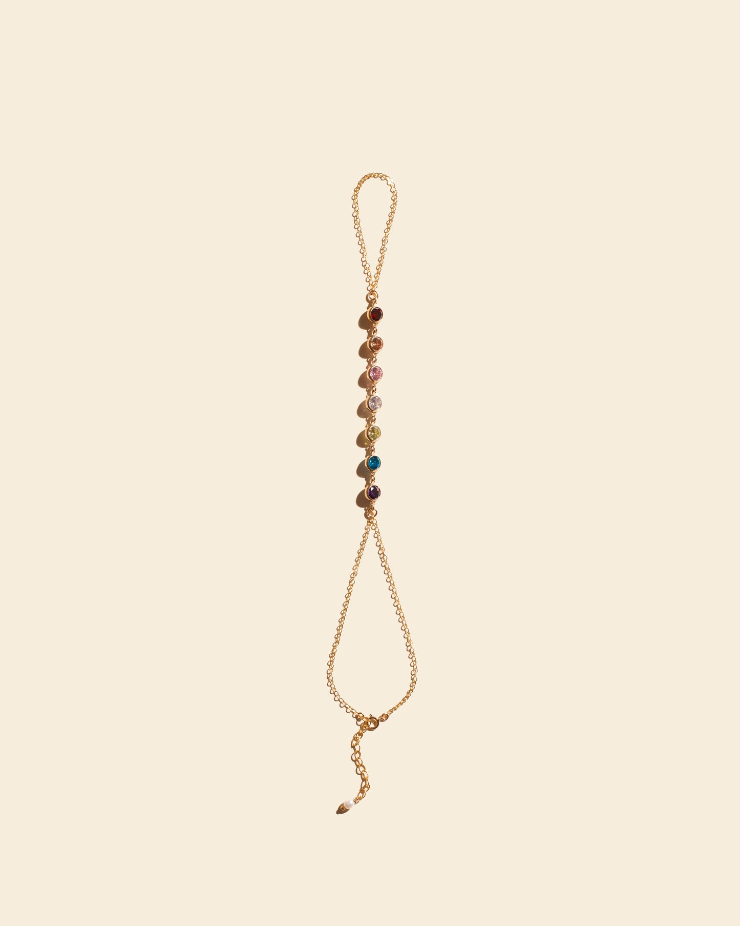 Chaîne de main 7 chakras, fine chaîne dorée ornée de cristaux arc-en-ciel représentant les 7 chakras. Bijou de créateur Apsara.